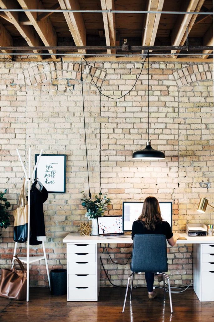 girl working at a computer with back turned towards camera