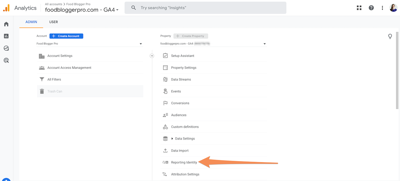 A screenshot of GA4 with an orange arrow pointing towards Reporting Identity.